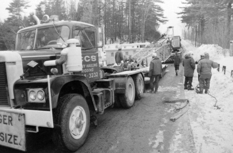 Black-and-white photo of a CCS heavy truck and crew working roadside in winter, January 1976